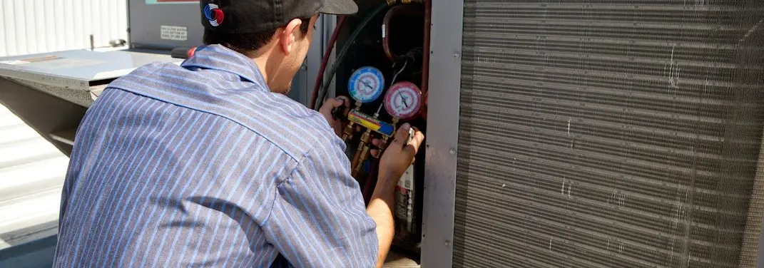 HVAC technician servicing a condenser unit in Keansburg
